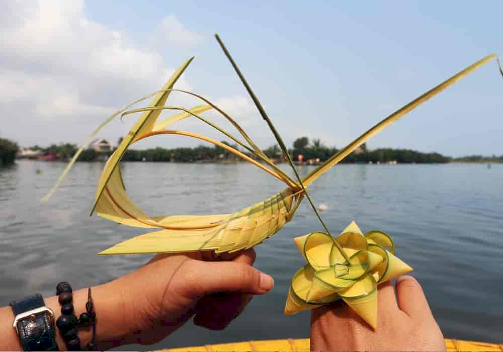 Under the guidance of skilled artisans, visitors can create unique items like grasshoppers, flowers, rings, and hats using freshly cut coconut leaves